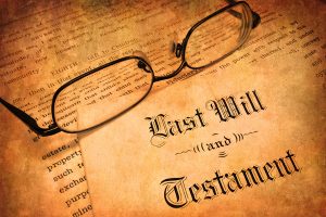 a picture of eyeglasses resting on a yellowed copy of a will and testament