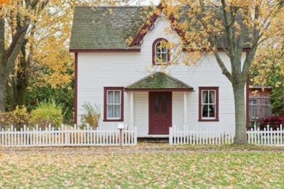 house sitting in winter and fall with leaves fallen and yellow on the grass in front of the home